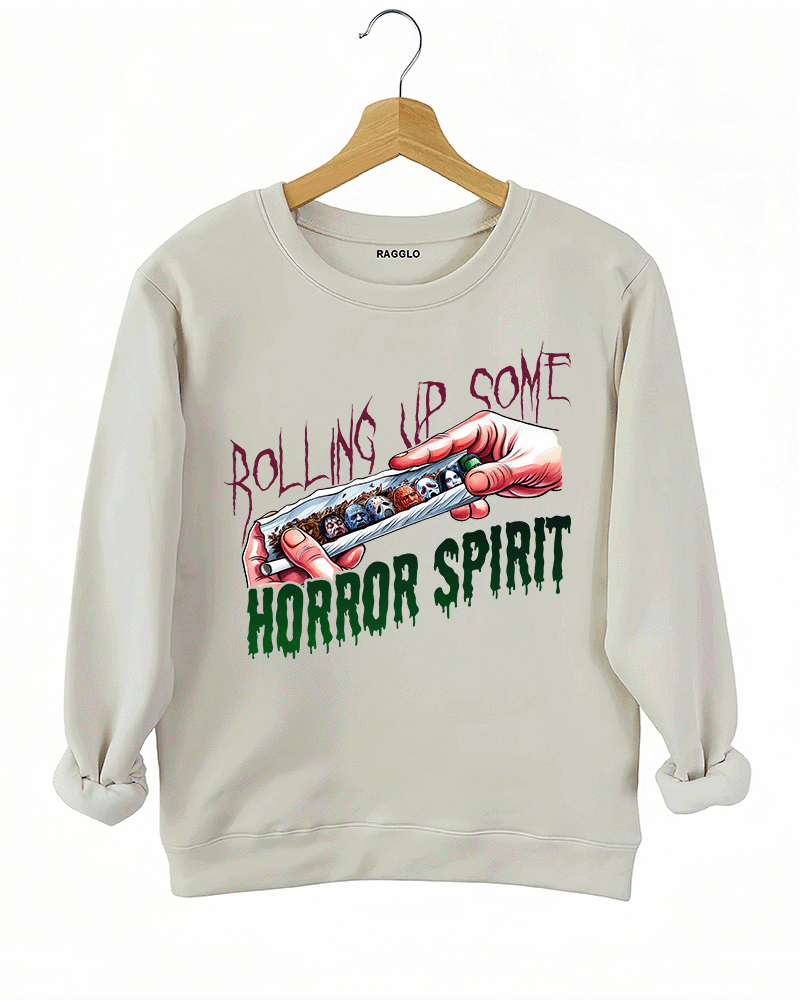 Ragglo beige sweatshirt featuring a hand rolling a cigarette with horror movie characters' faces, with 'ROLLING UP SOME HORROR SPIRIT' text, perfect for Halloween streetwear for horror movie fans.

