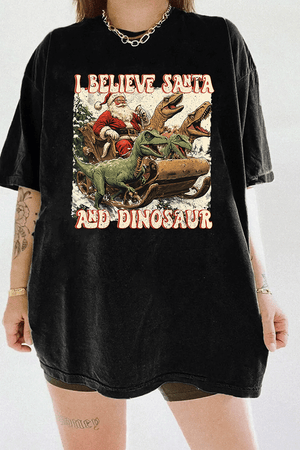Ragglo black women's tee with 'I Believe Santa and Dinosaur' text and Santa sleigh pulled by dinosaurs graphic.

