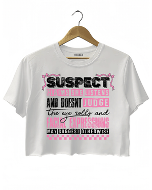 White Ragglo women's crop t-shirt with pink 'Suspect' design, featuring playful text: 'Claims she listens and doesn't judge, the eye rolls and facial expressions may suggest otherwise.

