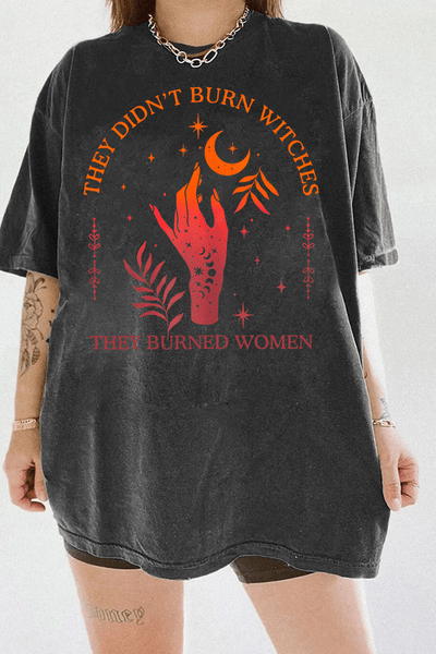 Ragglo dark gray women's T-shirt with 'They Didn’t Burn Witches, They Burned Women' text and flaming hand with mystical symbols graphic.

