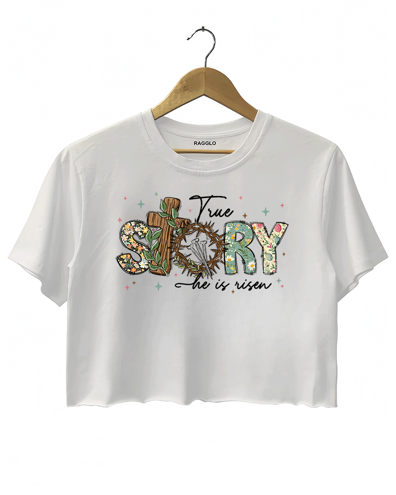 White Ragglo women's crop t-shirt with 'True Story He Is Risen' text, featuring a cross with a crown of thorns and floral design, ideal for Easter and Christian faith celebrations.

