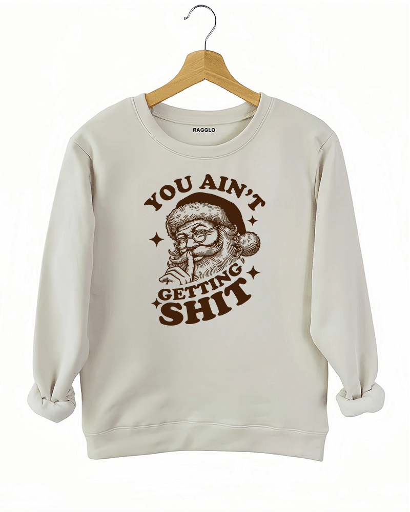Beige Ragglo women's sweatshirt made of soft fleece, featuring a Santa Claus graphic with the text "YOU AIN'T GETTING SHIT" in brown, hanging on a wooden hanger.

