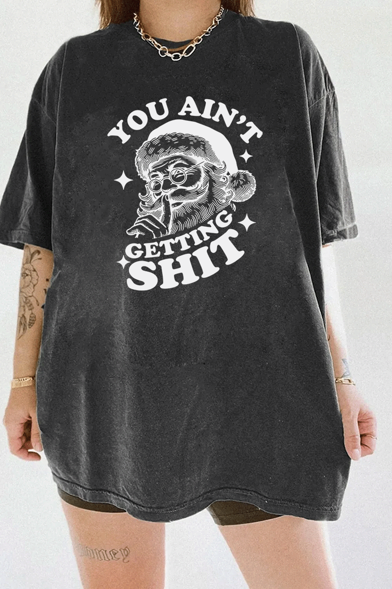 Dark gray Ragglo women's t - shirt with a funny Santa Claus graphic and the text "YOU AIN'T GETTING SHIT" in white, perfect for the holiday season, hanging on a wooden hanger.

