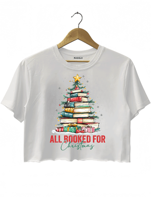 Ragglo white crop top featuring a Christmas tree made of stacked books, decorated with lights, stars, and gifts, with 'ALL BOOKED FOR CHRISTMAS' text, perfect for festive streetwear for book lovers.


