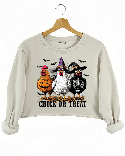 Ragglo beige crop sweatshirt featuring three chickens in Halloween costumes with pumpkins, witch hats, and skeleton designs, accented by bats and spiderwebs, with 'CHICK OR TREAT' text, perfect for funny Halloween streetwear.

