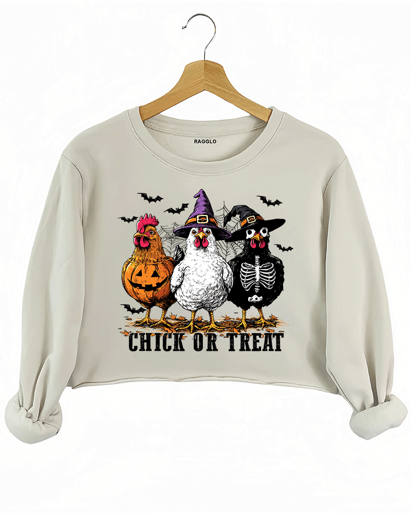 Ragglo beige crop sweatshirt featuring three chickens in Halloween costumes with pumpkins, witch hats, and skeleton designs, accented by bats and spiderwebs, with 'CHICK OR TREAT' text, perfect for funny Halloween streetwear.

