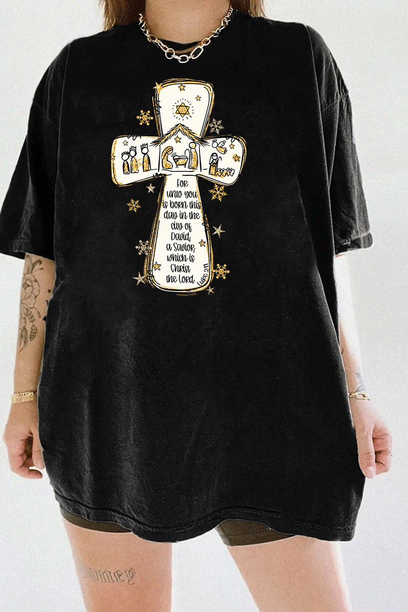 Ragglo black tee featuring a cross with a nativity scene, stars, and snowflakes, with 'Unto you is born this day in the city of David, a Savior which is Christ the Lord' text, perfect for religious Christmas streetwear.

