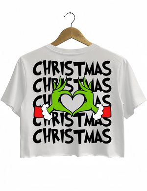 Ragglo white women's crop top back featuring larger Grinch hands making a heart shape with Santa cuffs, surrounded by the repeated text 'Christmas' in a humorous holiday graphic design.