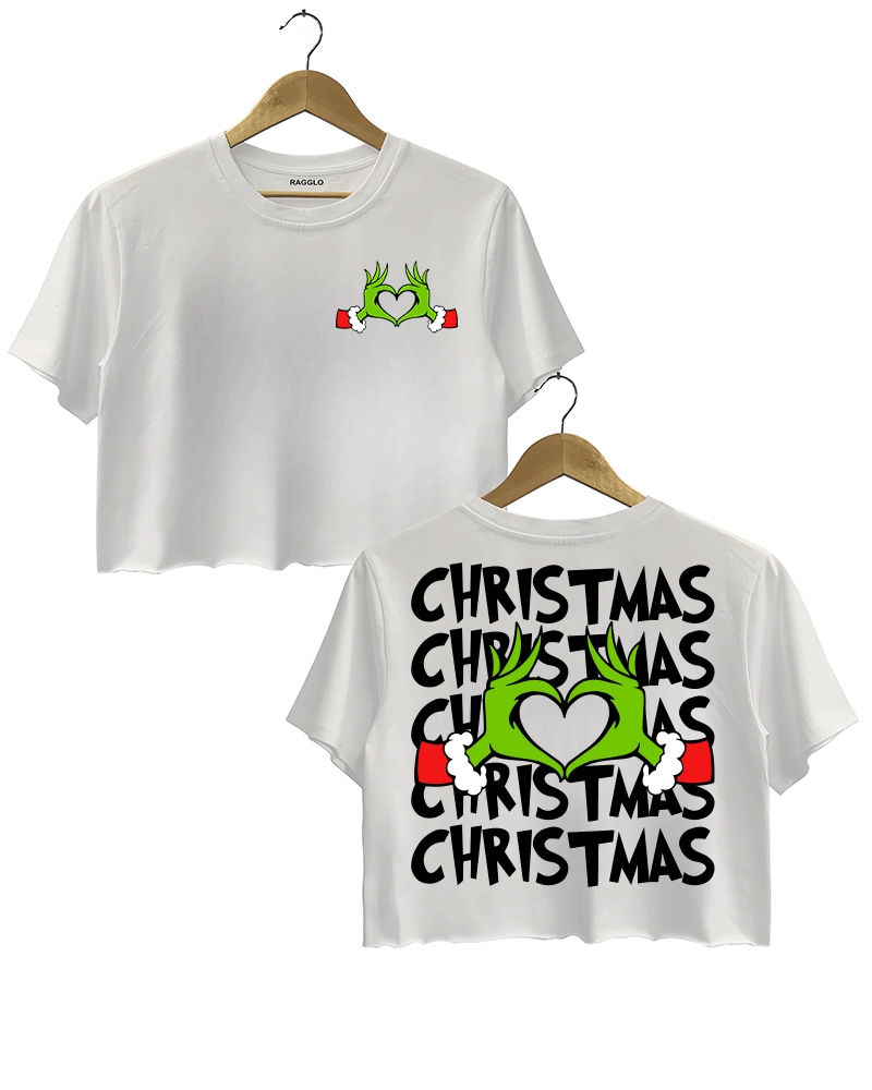 Ragglo white women's crop top featuring Grinch hands making a heart shape with Santa cuffs on the front, and larger Grinch hands with 'Christmas' text repeated around them on the back, in a funny holiday graphic design.