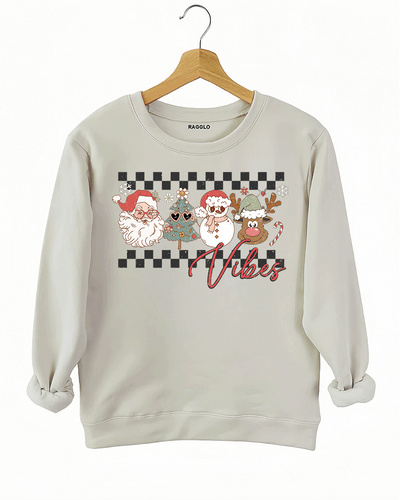 Ragglo beige sweatshirt with "Vibes" text and Christmas graphic featuring Santa, snowman, and reindeer, showcasing a festive holiday theme with a checkered background.

