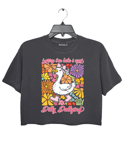 Ragglo dark gray crop top featuring a cute duck in pink rain boots and a bow, surrounded by vibrant flowers, with 'Sorry I'm Late I Was Dilly Dallying' text, perfect for playful floral-inspired casual wear.

