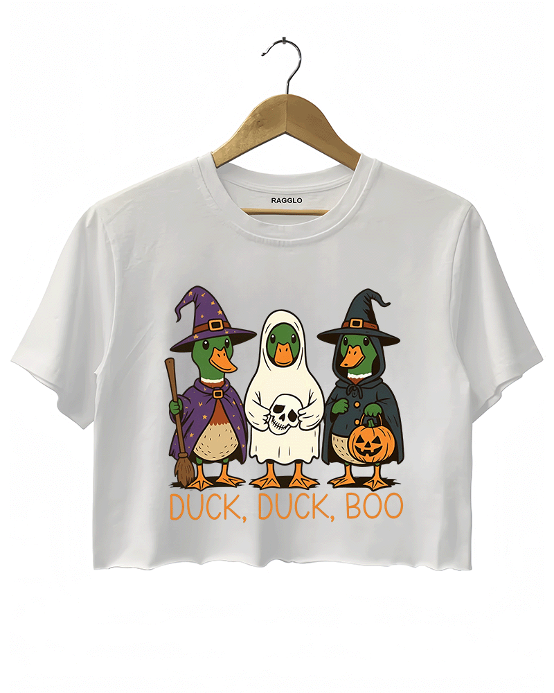 White crop top featuring three cute ducks dressed in Halloween costumes: a purple wizard, a ghost in a white sheet, and a witch with a pumpkin lantern. The text 'DUCK, DUCK, BOO' is printed below the characters in orange.