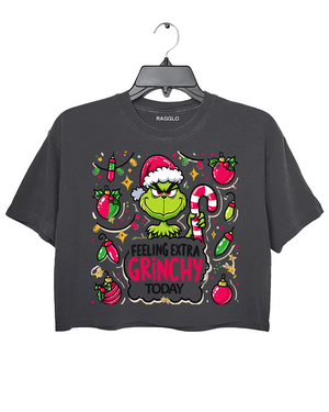 Ragglo dark gray crop top featuring the Grinch in a Santa hat, surrounded by candy canes, lights, and ornaments, with 'FEELING EXTRA GRINCHY TODAY' text, perfect for funny Christmas streetwear.

