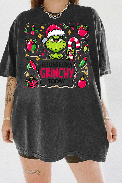 Ragglo dark gray tee featuring the Grinch in a Santa hat, surrounded by candy canes, lights, and ornaments, with 'FEELING EXTRA GRINCHY TODAY' text, perfect for funny Christmas streetwear.


