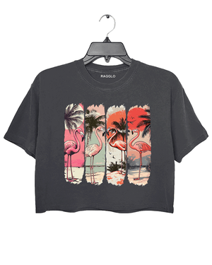 Ragglo dark gray crop top featuring four pink flamingos on a beach with palm trees and a vibrant sunset, perfect for tropical-inspired casual wear.

