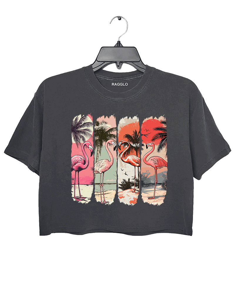 Ragglo dark gray crop top featuring four pink flamingos on a beach with palm trees and a vibrant sunset, perfect for tropical-inspired casual wear.

