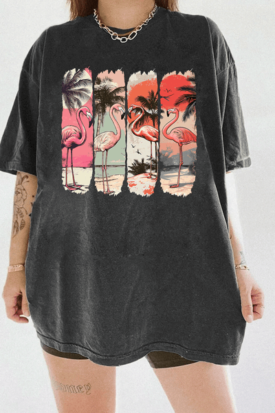 Ragglo dark gray tee featuring four pink flamingos on a beach with palm trees and a vibrant sunset, perfect for tropical-inspired casual wear.

