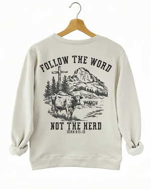 Ragglo beige women's sweatshirt back featuring a mountain landscape with cattle, a cross, and trees, and the text 'Follow The Word Not The Herd' and 'Isaiah 8:11-13' in a spiritual graphic design.