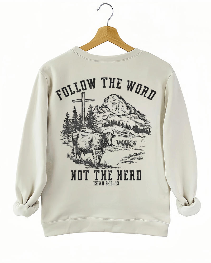 Ragglo beige women's sweatshirt back featuring a mountain landscape with cattle, a cross, and trees, and the text 'Follow The Word Not The Herd' and 'Isaiah 8:11-13' in a spiritual graphic design.