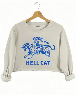 Ragglo beige crop sweatshirt featuring 'HELL CAT' text in blue with a graphic of a woman riding a tiger, perfect for bold streetwear and fierce, rebellious vibes.





