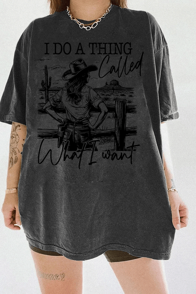 Ragglo dark gray T-shirt with "I Do A Thing Called What I Want" text and cowgirl graphic in a desert scene, featuring a bold western independence theme.

