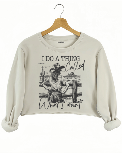 Ragglo beige crop sweatshirt with "I Do A Thing Called What I Want" text and cowgirl graphic in a desert scene, featuring a bold western independence theme.

