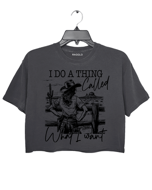 Ragglo dark gray crop top with "I Do A Thing Called What I Want" text and cowgirl graphic in a desert scene, featuring a bold western independence theme.

