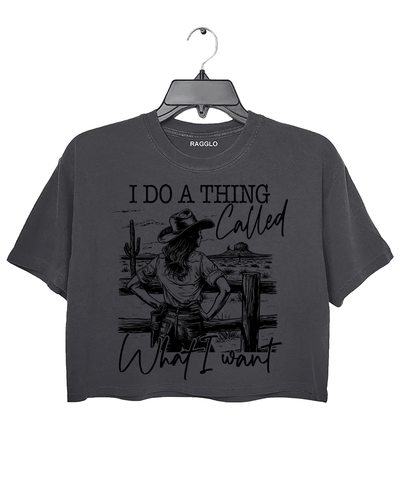 Ragglo dark gray crop top with "I Do A Thing Called What I Want" text and cowgirl graphic in a desert scene, featuring a bold western independence theme.

