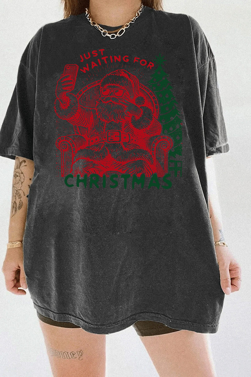 Ragglo dark gray T-shirt featuring a Santa selfie graphic with sunglasses, a Christmas tree, and 'JUST WAITING FOR CHRISTMAS' text, perfect for festive holiday streetwear and fun celebrations.

