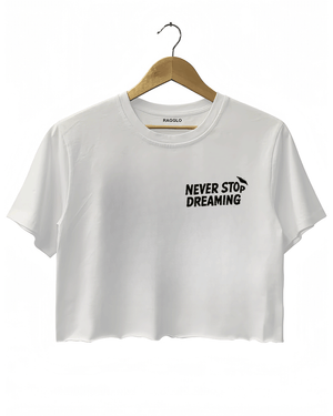 White crop top with the text 'NEVER STOP DREAMING' in bold black font on the left chest.