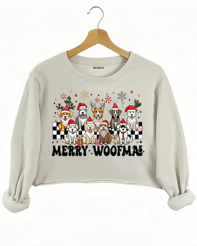 Ragglo beige crop sweatshirt featuring eight dogs in Santa hats and reindeer antlers with gifts, snowflakes, and 'MERRY WOOFMAS' text, perfect for festive Christmas streetwear for dog lovers.

