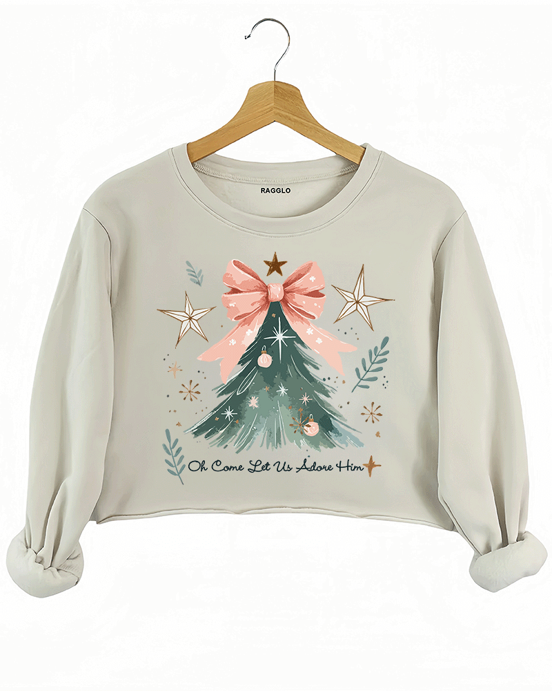 Ragglo beige crop sweatshirt featuring a Christmas tree with a pink bow, stars, snowflakes, and branches, with 'Oh Come Let Us Adore Him' text, perfect for religious Christmas streetwear.








