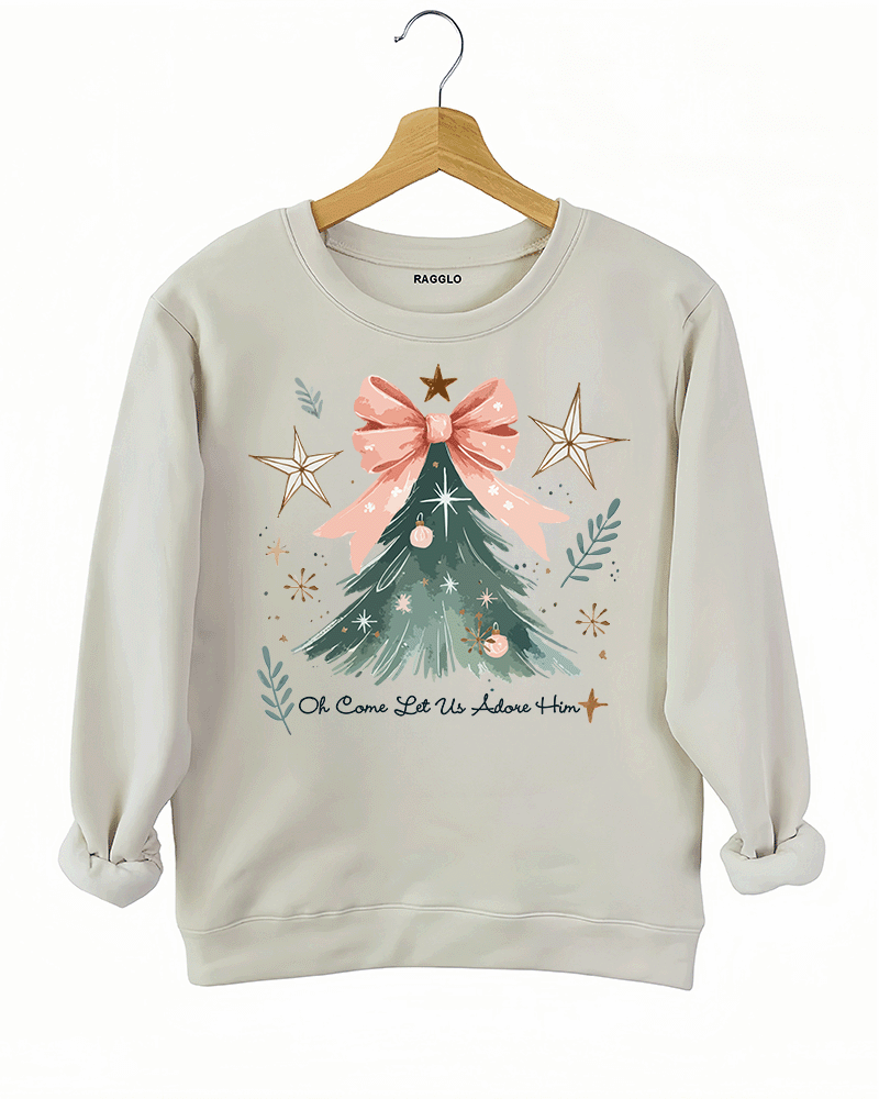 Ragglo beige sweatshirt featuring a Christmas tree with a pink bow, stars, snowflakes, and branches, with 'Oh Come Let Us Adore Him' text, perfect for religious Christmas streetwear.







