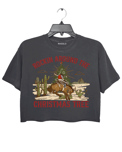 Ragglo dark gray crop top featuring a cowboy riding a horse with a Christmas tree in a desert scene with cacti, with 'ROCKIN AROUND THE CHRISTMAS TREE' text, perfect for festive western-style streetwear.

