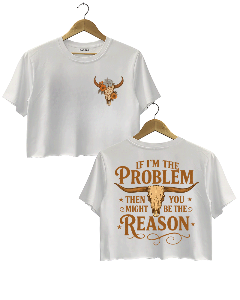 White crop top with a bull skull and floral design on the front, and the phrase 'IF I'M THE PROBLEM THEN YOU MIGHT BE THE REASON' with a bull skull graphic on the back. Both sides feature vibrant orange accents.