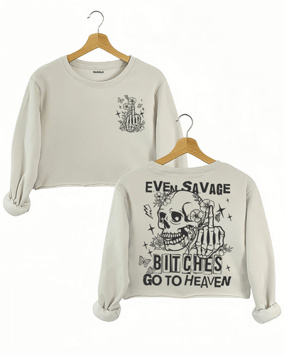 Ragglo beige crop sweatshirt featuring front and back views: the front shows a skeleton hand with a middle finger gesture surrounded by flowers, butterflies, and stars; the back displays a skull with a skeleton hand giving a middle finger, surrounded by flowers, butterflies, and stars, with 'EVEN SAVAGE BITCHES GO TO HEAVEN' text, perfect for bold and humorous streetwear.

