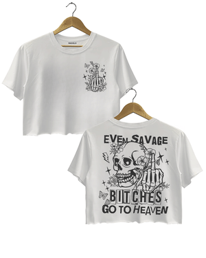 Ragglo white crop top featuring front and back views: the front shows a skeleton hand with a middle finger gesture surrounded by flowers, butterflies, and stars; the back displays a skull with a skeleton hand giving a middle finger, surrounded by flowers, butterflies, and stars, with 'EVEN SAVAGE BITCHES GO TO HEAVEN' text, perfect for bold and humorous streetwear.

