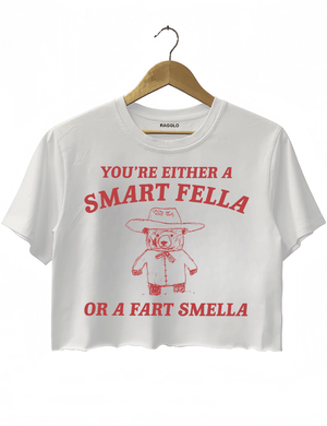 Ragglo white crop top featuring 'YOU’RE EITHER A SMART FELLA OR A FART SMELLA' text with a bear in a cowboy hat, perfect for casual streetwear and humorous everyday wear.

