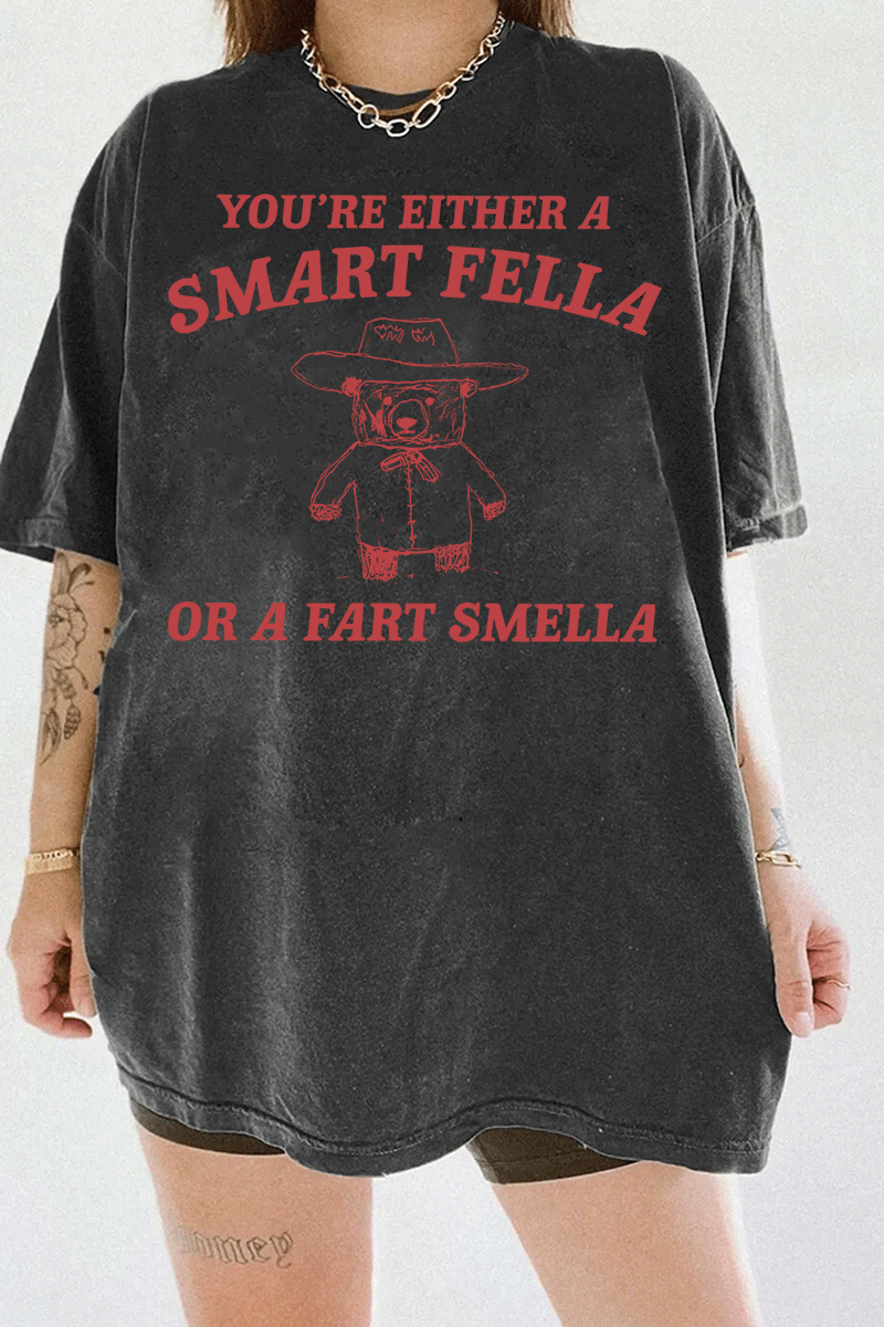 Ragglo dark gray tee featuring 'YOU’RE EITHER A SMART FELLA OR A FART SMELLA' text with a bear in a cowboy hat, perfect for casual streetwear and humorous everyday wear.

