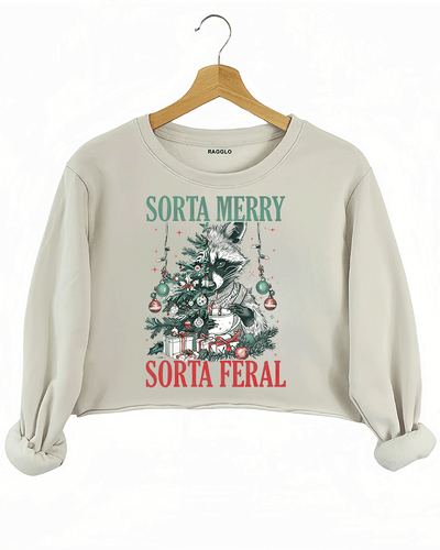 Ragglo beige crop sweatshirt featuring a raccoon with a decorated Christmas tree, gifts, and 'SORTA MERRY SORTA FERAL' text, perfect for funny Christmas streetwear.

