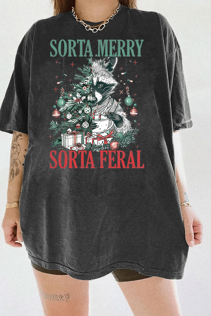 Ragglo dark gray tee featuring a raccoon with a decorated Christmas tree, gifts, and 'SORTA MERRY SORTA FERAL' text, perfect for funny Christmas streetwear.

