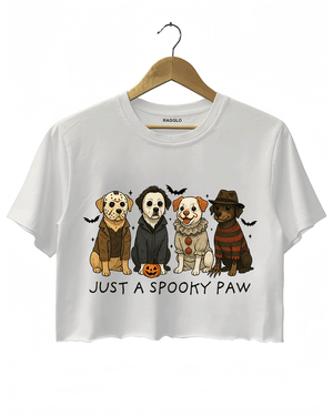 White cropped T-shirt by RAGGLO showcasing four adorable cartoon dogs in Halloween horror costumes, styled after classic characters like Freddy Krueger, Michael Myers, Pennywise, and Billy the Puppet. Accented with bats and a pumpkin, and the phrase "JUST A SPOOKY PAW" beneath the artwork. A fun and festive piece for Halloween lovers.