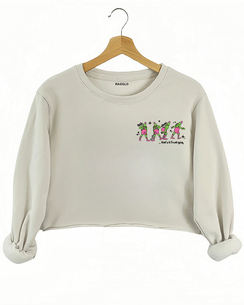 Ragglo beige women's crop sweatshirt front featuring three Grinch characters with Santa hats and the text 'Oh, That’s It I’m Trippin'' in a funny Christmas graphic design.