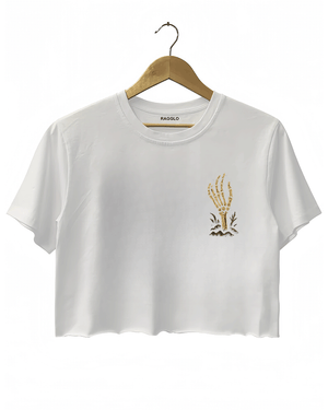 Front view of a white cropped Halloween T-shirt by RAGGLO, with a minimal gold skeleton hand graphic on the left chest, holding a small flame. Simple yet spooky, perfect for a casual Halloween look.