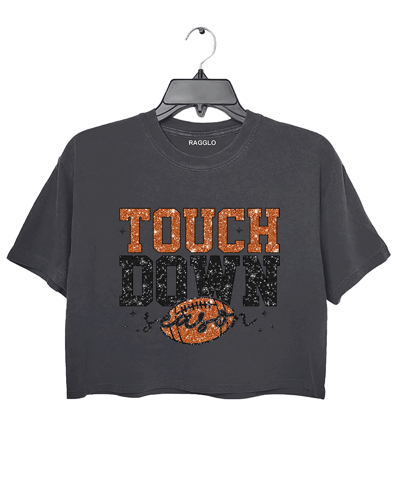 Ragglo dark gray crop top featuring 'TOUCH DOWN' text with a football graphic and 'season' script, accented by stars, perfect for football fans and game day streetwear.

