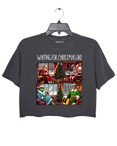 Ragglo dark gray crop top featuring four classic Christmas movie characters waiting by decorated trees with 'WAITING FOR CHRISTMAS LIKE' text, perfect for festive holiday streetwear and movie fans.


