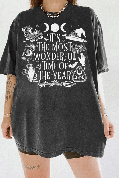 Ragglo dark gray tee featuring witchy elements like moons, bats, a witch hat, spellbook, and potion bottle, with 'IT’S THE MOST WONDERFUL TIME OF THE YEAR' text, perfect for magical Halloween streetwear.

