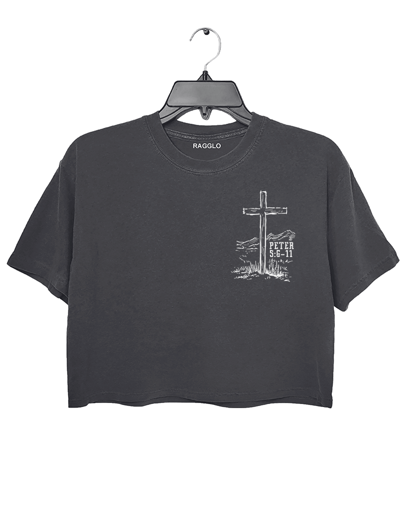 Dark gray Ragglo women's crop t-shirt with a cross and 'Peter 5:6-11' scripture in a western landscape, ideal for Christian faith-inspired fashion.

