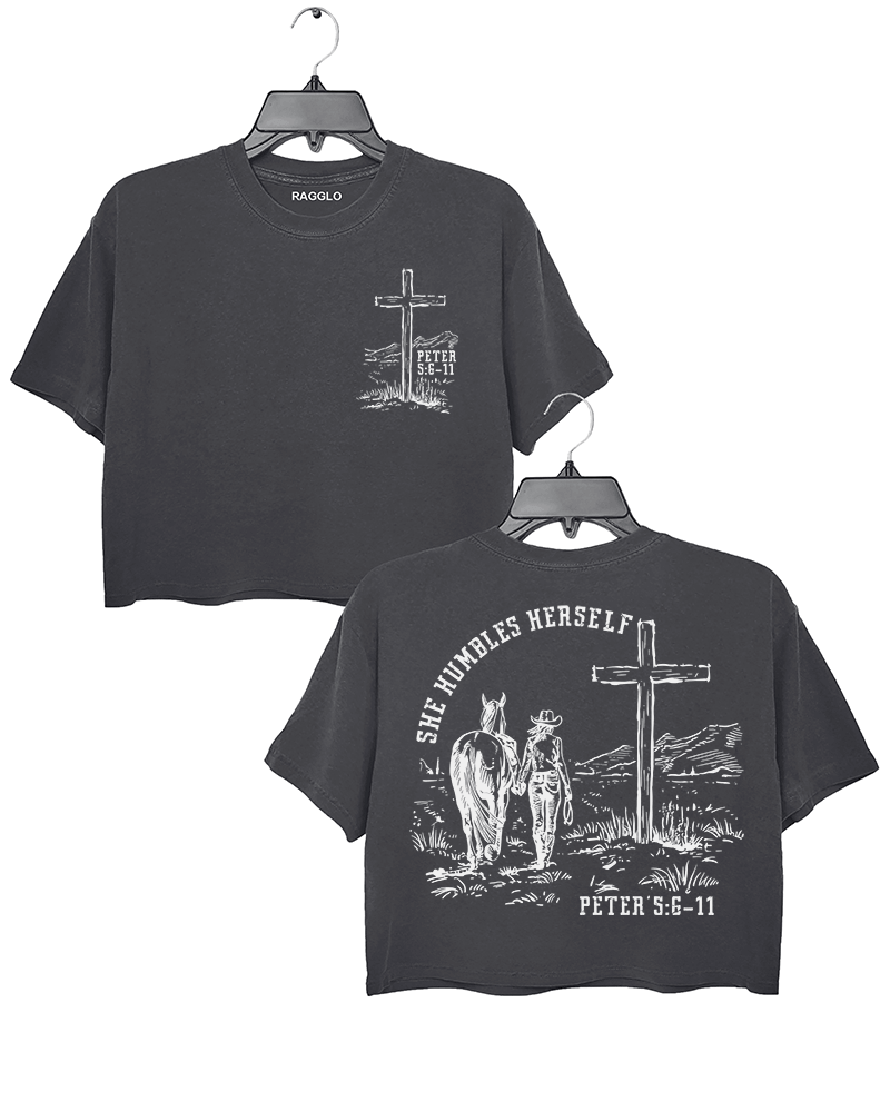 Dark Gray Ragglo women's crop t-shirt featuring front and back designs with 'She Humbles Herself' text, a cowgirl with a horse, a cross, and Peter 5:6-11 scripture, perfect for Christian faith and western-inspired fashion.

