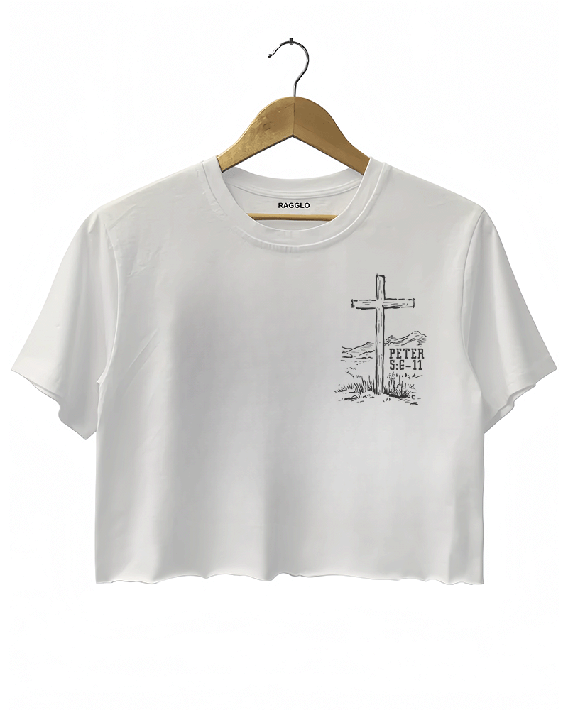 White Ragglo women's crop t-shirt with a cross and 'Peter 5:6-11' scripture in a western landscape, ideal for Christian faith-inspired fashion.

